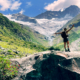 Über die Chakrenlehre Eine junge Frau steht auf einem Felsen in einem Alpen Hochtal und öffnet sich der schöpferischen Energie